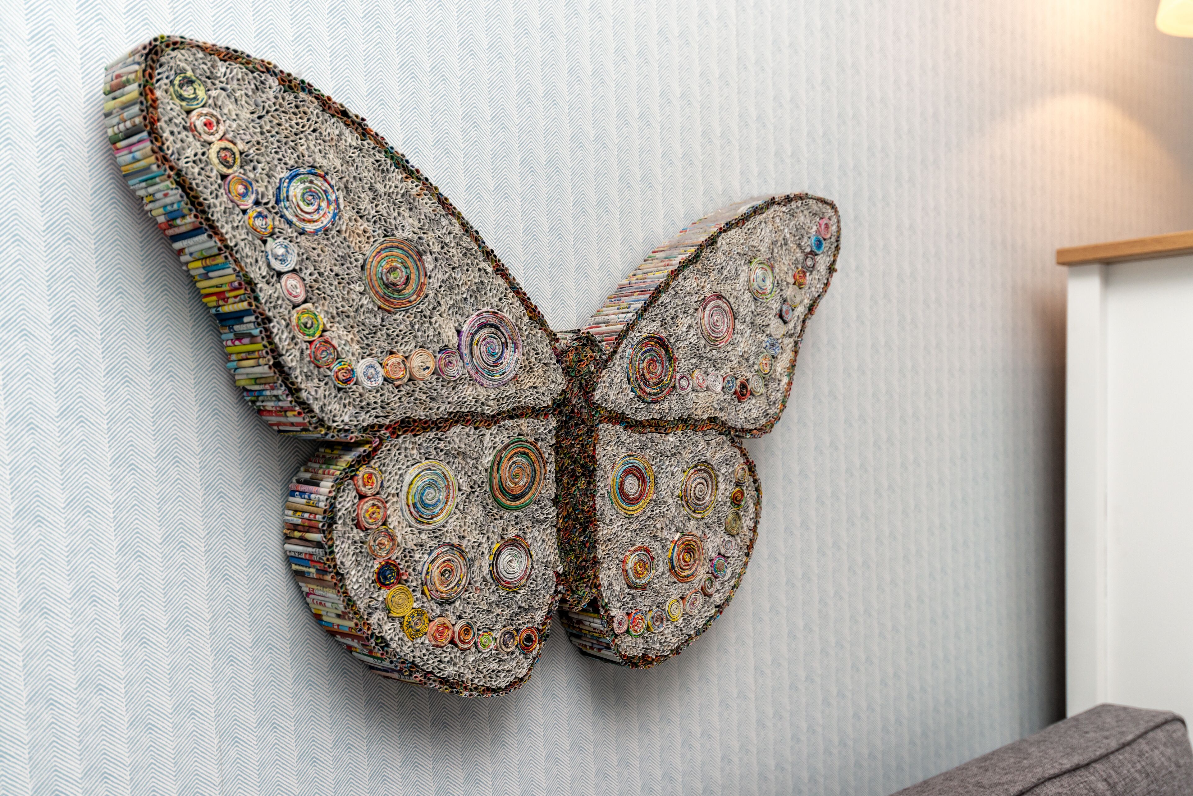 A wall-mounted butterfly sculpture with intricate patterns.
