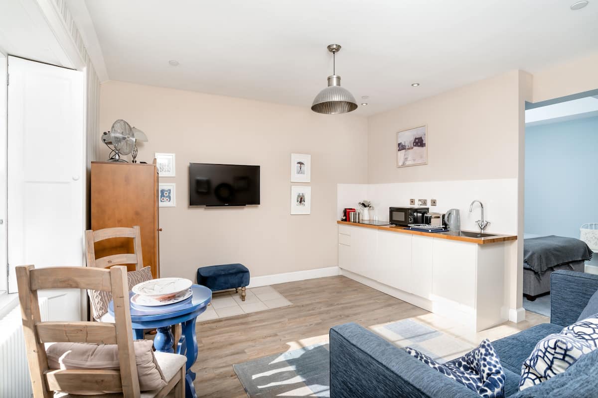 A compact living space with a kitchenette, a dining area, and a seating area.