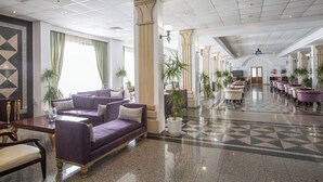 A spacious lobby with a purple sofa, a reception desk, and a check-in counter. - Tsokkos Gardens (Paralimni)