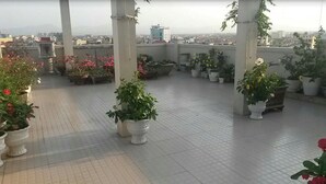 A rooftop terrace with potted plants and a view of the cityscape. - Nam Long Plus Hotel (Dong Hoi)
