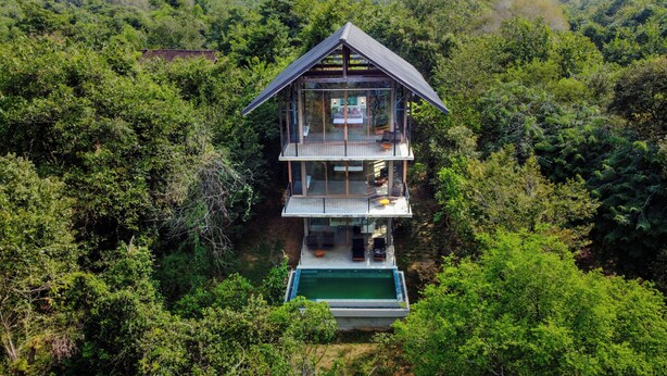 A multi-level wooden cabin with glass walls, surrounded by dense forest. - Wild Grass Nature Resort (Dambulla)