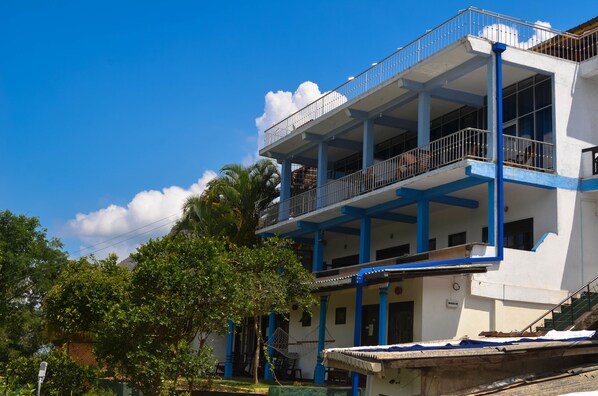 A multi-story building with balconies and a blue and white color scheme.