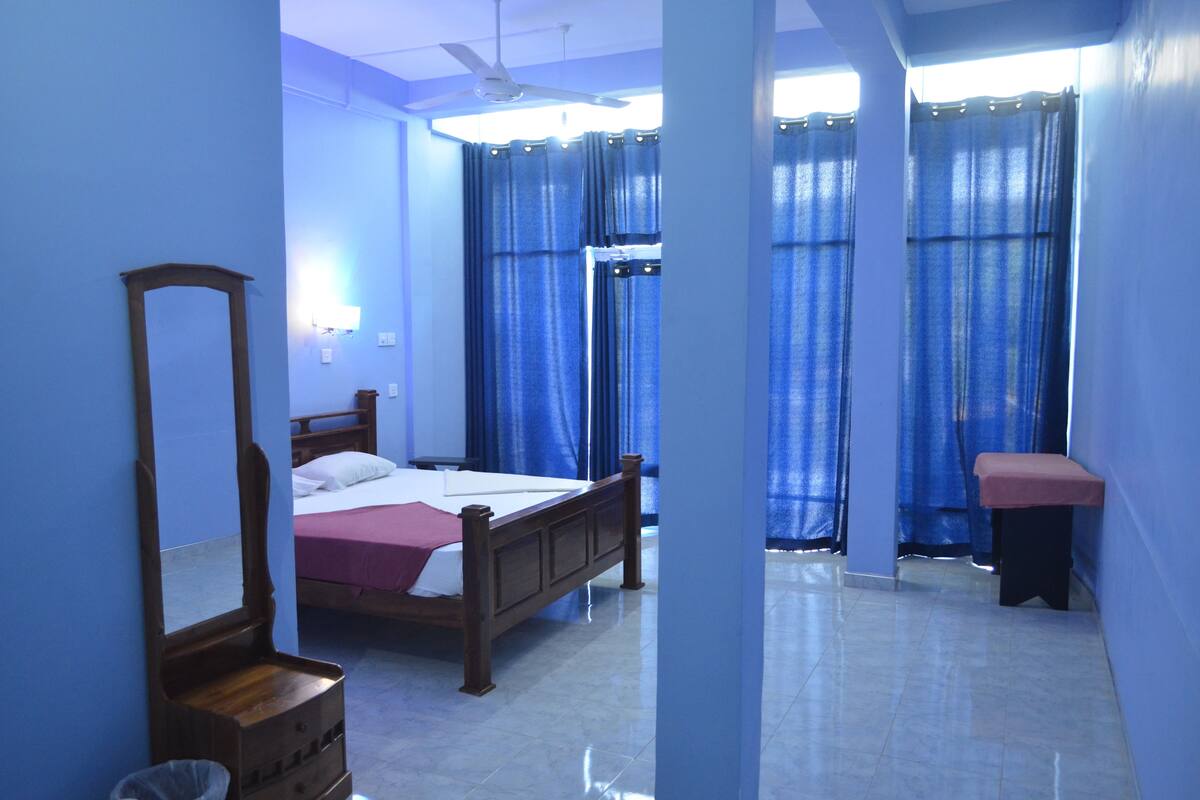 A bedroom with a wooden bed, a nightstand, a mirror, and a bench.