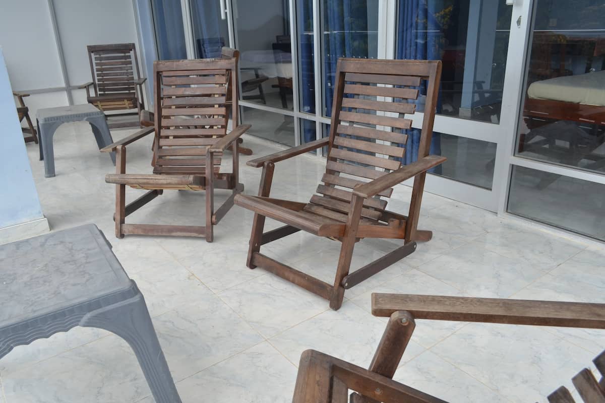 A room with wooden chairs and a plastic stool.