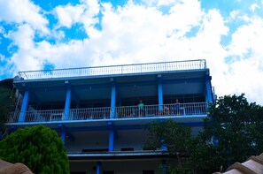 A multi-story building with blue structural elements and a balcony.