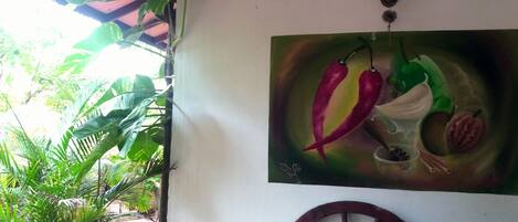 A wall with a painting of chili peppers and a wheel.