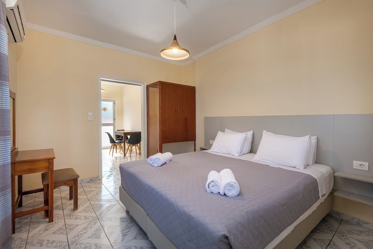 Ein Hotelzimmer mit Bett, Schreibtisch, Stuhl und Kleiderschrank.