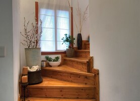 Una escalera de madera con plantas en macetas y un candelabro.