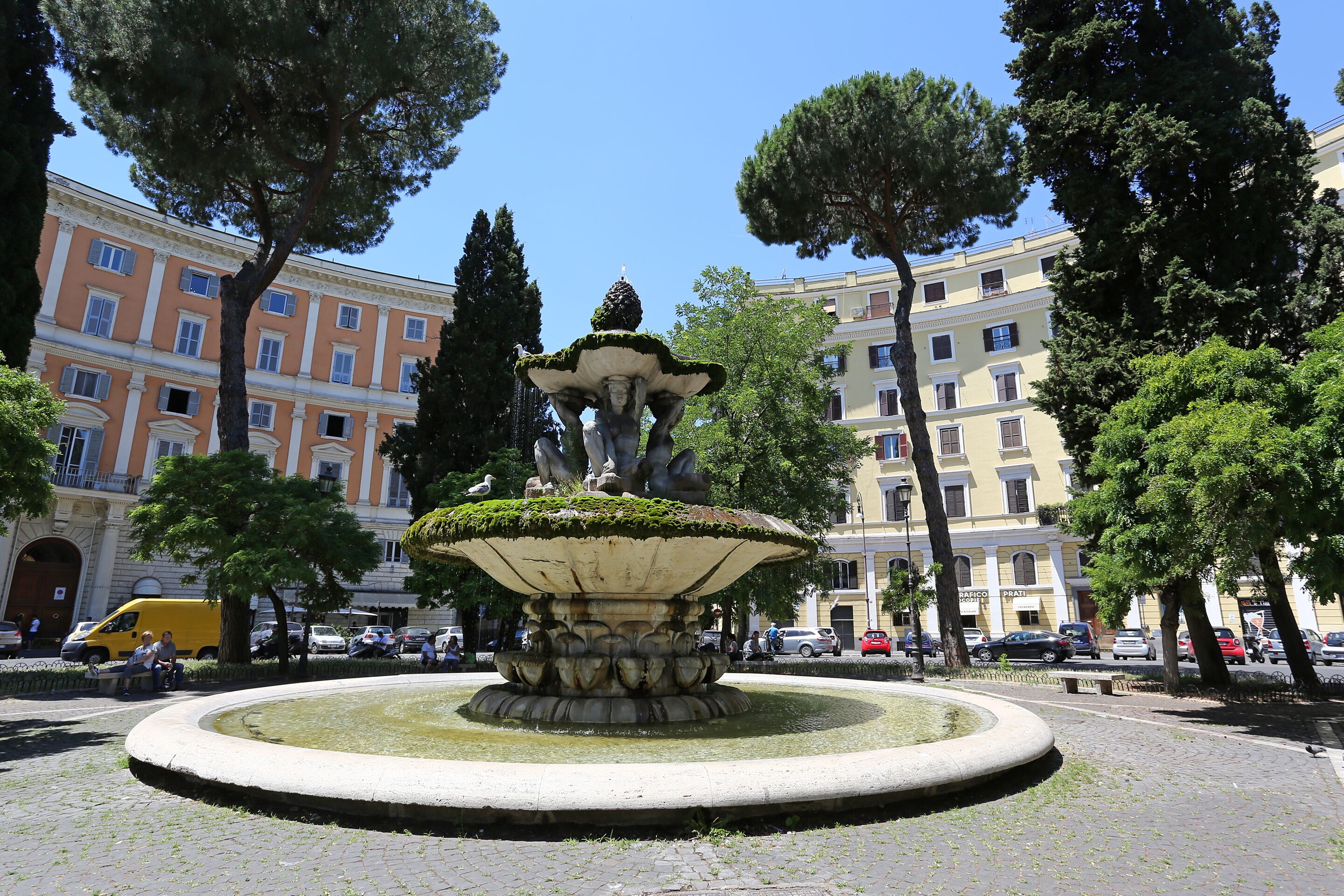 A fountain with a statue in the center, surrounded by a circular stone border.