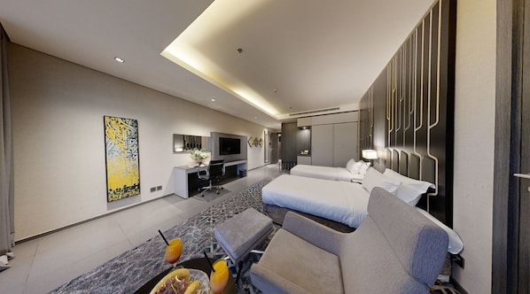 A modern hotel room with a large bed, a sofa, a desk, and a TV.