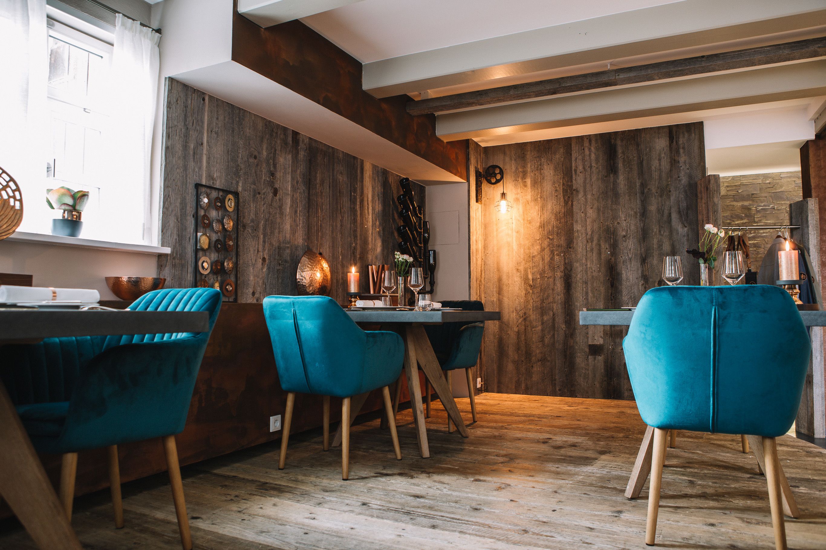 A dining area with wooden walls, a wooden ceiling, and a table with chairs.