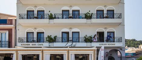 A building with a sign reading "DALI LUXURY ROOMS" and "KITCHEN BAR-CAFE" on the ground floor.