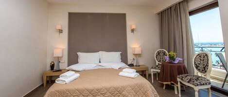 A hotel room with a large bed, two bedside tables with lamps, a chair, and a balcony view.
