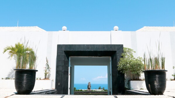 A modern entrance with a black archway leading to a view of the ocean.