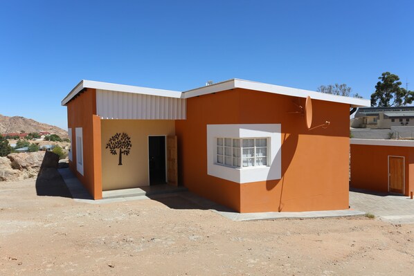 A modern building with a flat roof, a large window, and a door. - Aus Self-Catering Units (Aus)