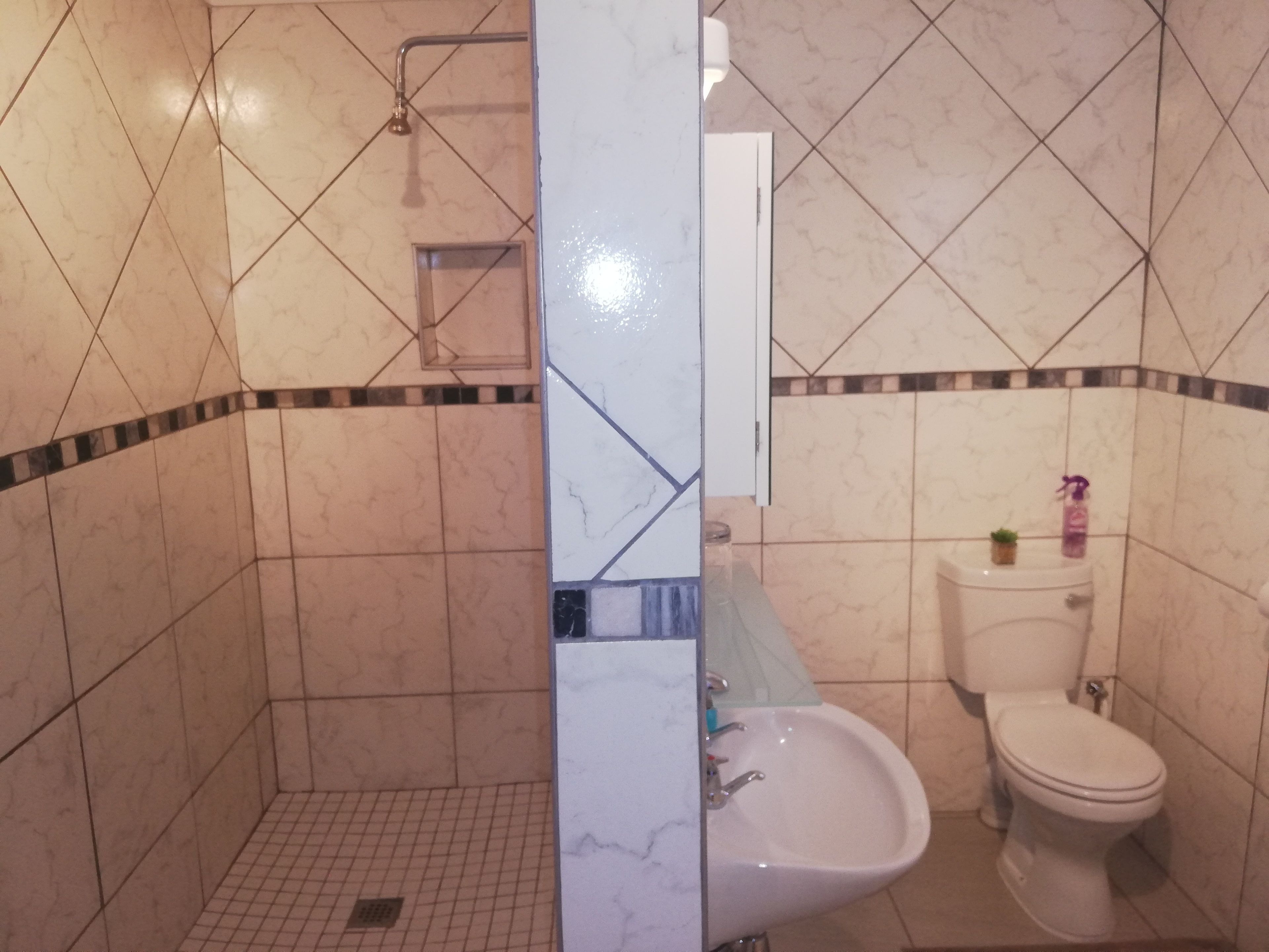 Un baño con ducha, inodoro y lavabo.