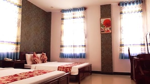 A hotel room with two beds, a desk, and a chair. - Thi Long Phung Hotel (Phu Quoc)