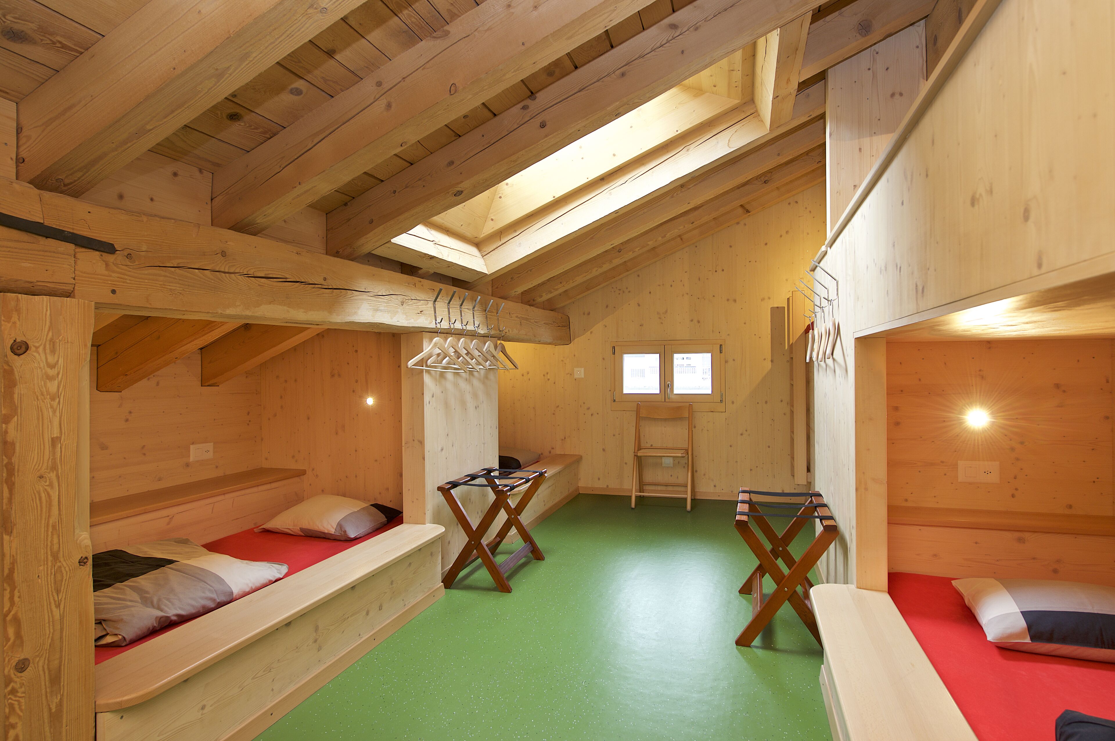 Una cabaña de madera con literas, una mesa pequeña y una ventana.
