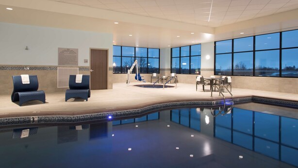 An indoor swimming pool with lounge chairs and a sun terrace.