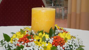 A table with a candle and a floral arrangement.