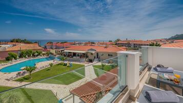 Un hotel con piscina, zona de estar al aire libre y vistas al mar.