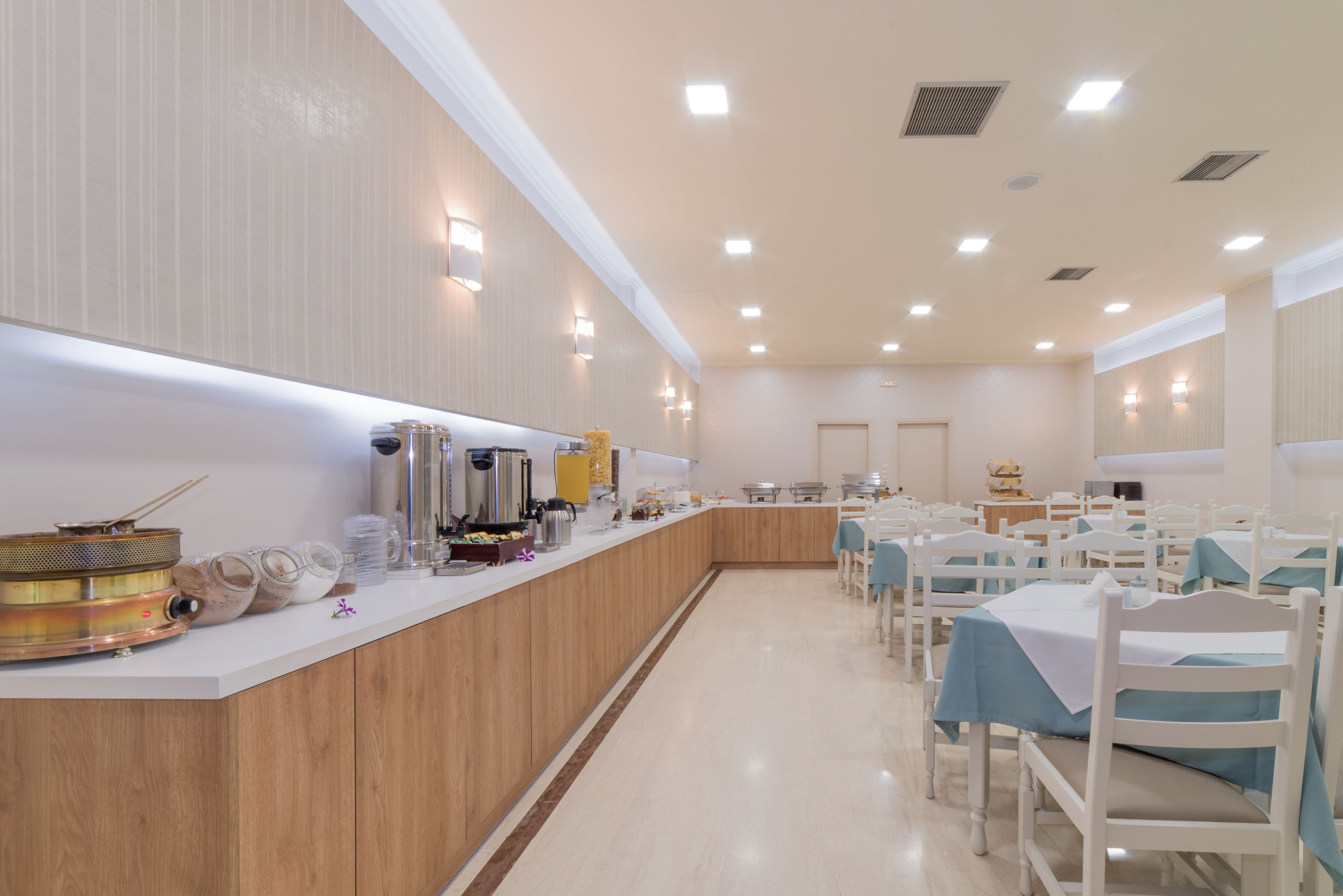 A spacious dining area with a long counter, multiple tables, and chairs.
