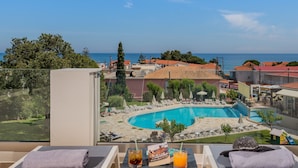 Un balcón con vista a una piscina y al mar.