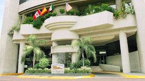 A modern building with a curved facade, multiple windows, and a sign reading "San Marcos." - Hotel San Marcos Grand (Culiacán)