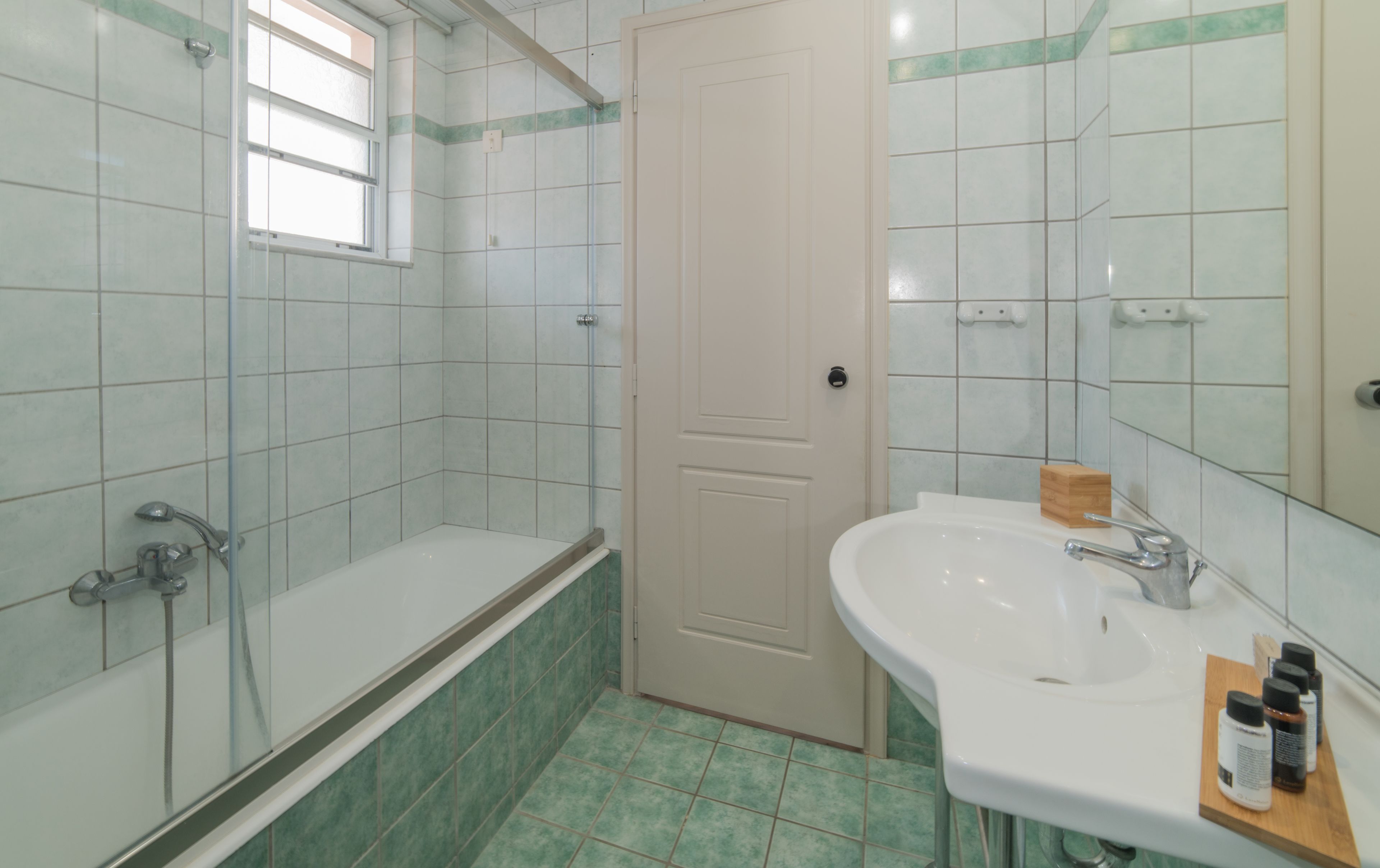 Ein Badezimmer mit Dusche, Waschbecken und Spiegel.