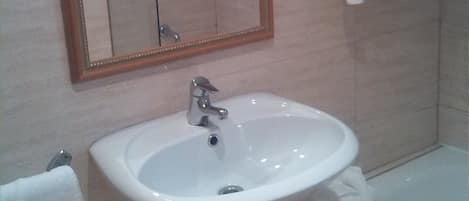 Un bagno con lavandino, specchio e vasca da bagno.