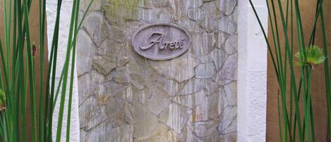 A stone wall with a sign that reads "Avenue."