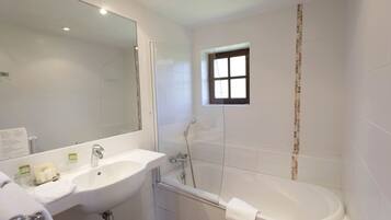Une salle de bain moderne avec un grand miroir, un lavabo, une baignoire et une douche.
