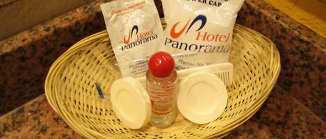 A wicker basket containing toiletries and a shower cap on a granite countertop.
