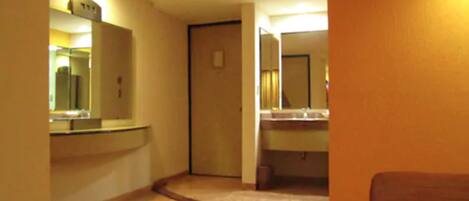 A hotel bathroom with a sink, mirror, and toilet.