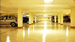 Un aparcamiento de varios niveles con un suelo brillante y reflectante y varios coches estacionados.