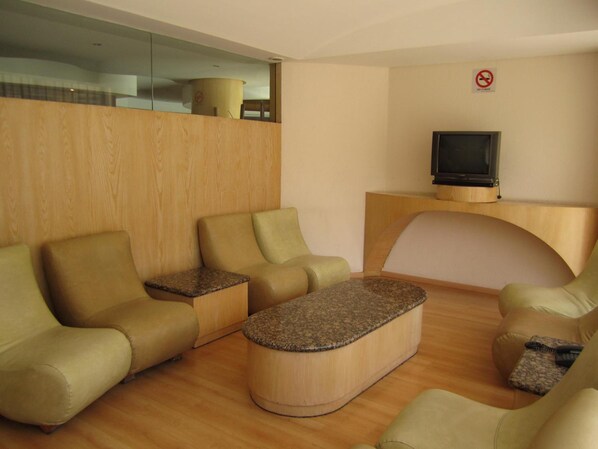 Una sala de estar moderna con televisor, dos sofás, una mesita de centro y una pared de acento de madera.