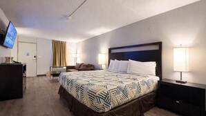 Une chambre d’hôtel avec un grand lit, deux lampes de chevet, un téléviseur à écran plat, un bureau et une chaise.