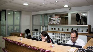 Un mostrador de recepción con encimera de madera, un teléfono y una exhibición de revistas.