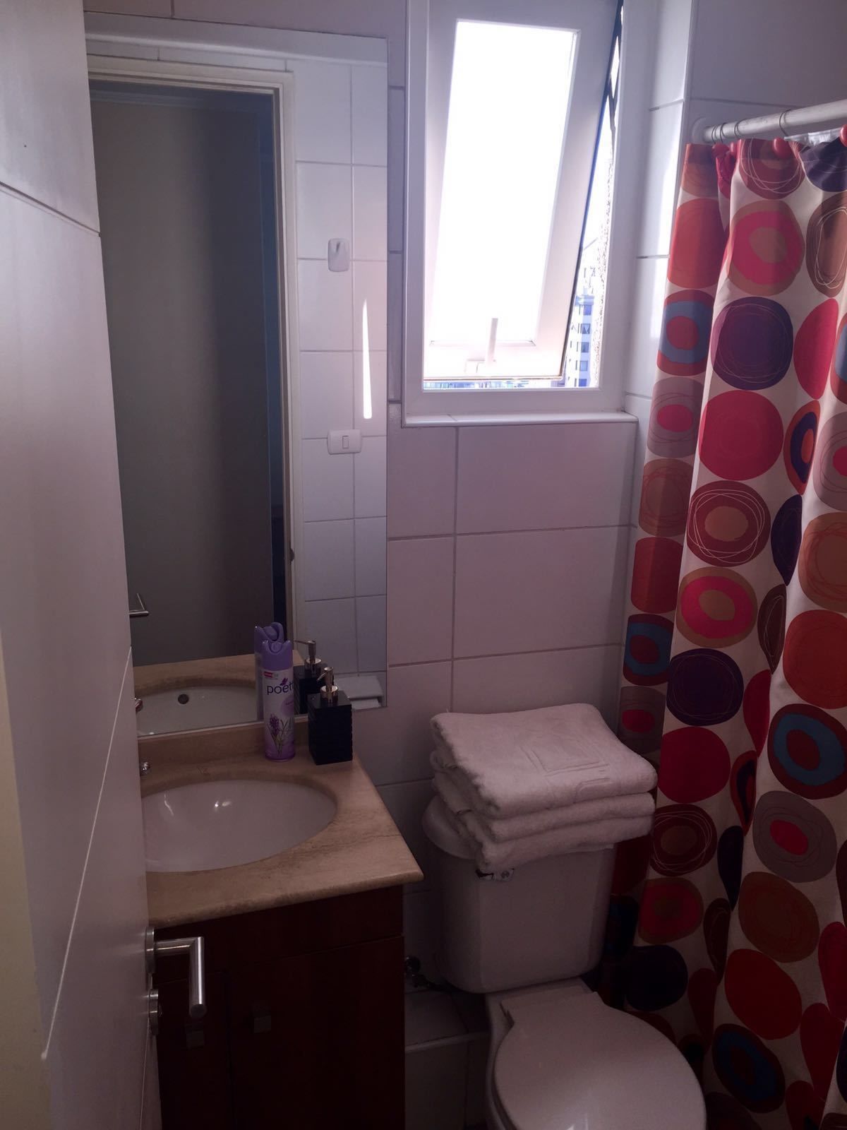 Un baño con lavamanos, inodoro y ventana.