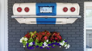 A vintage car with a Connecticut license plate and a flower planter below it. - Iron Masters - Inn on Main (Lakeville)