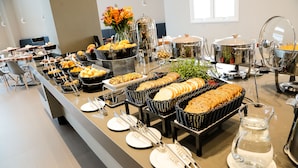 Een buffetopstelling met diverse gerechten en bestek.