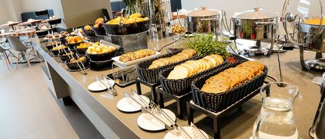 Una mesa de buffet con diferentes alimentos y utensilios.