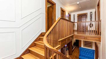 A wooden staircase with a blue bench at the bottom landing.