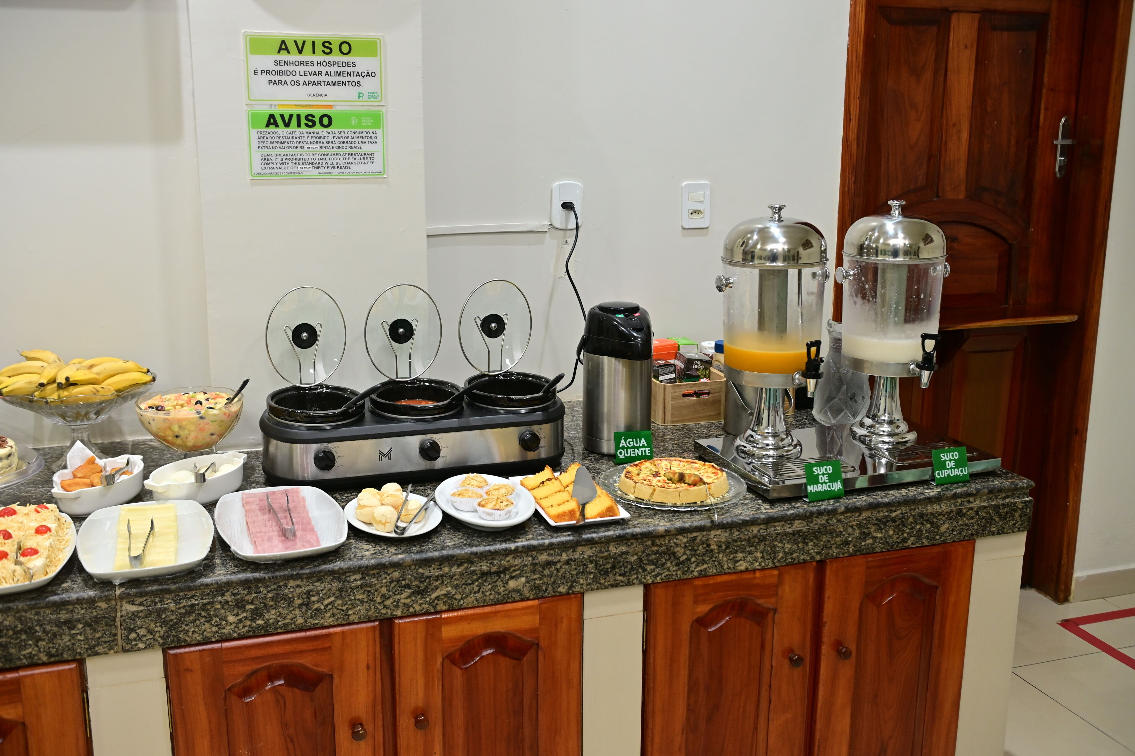 A buffet setup with various food items and a coffee station.
