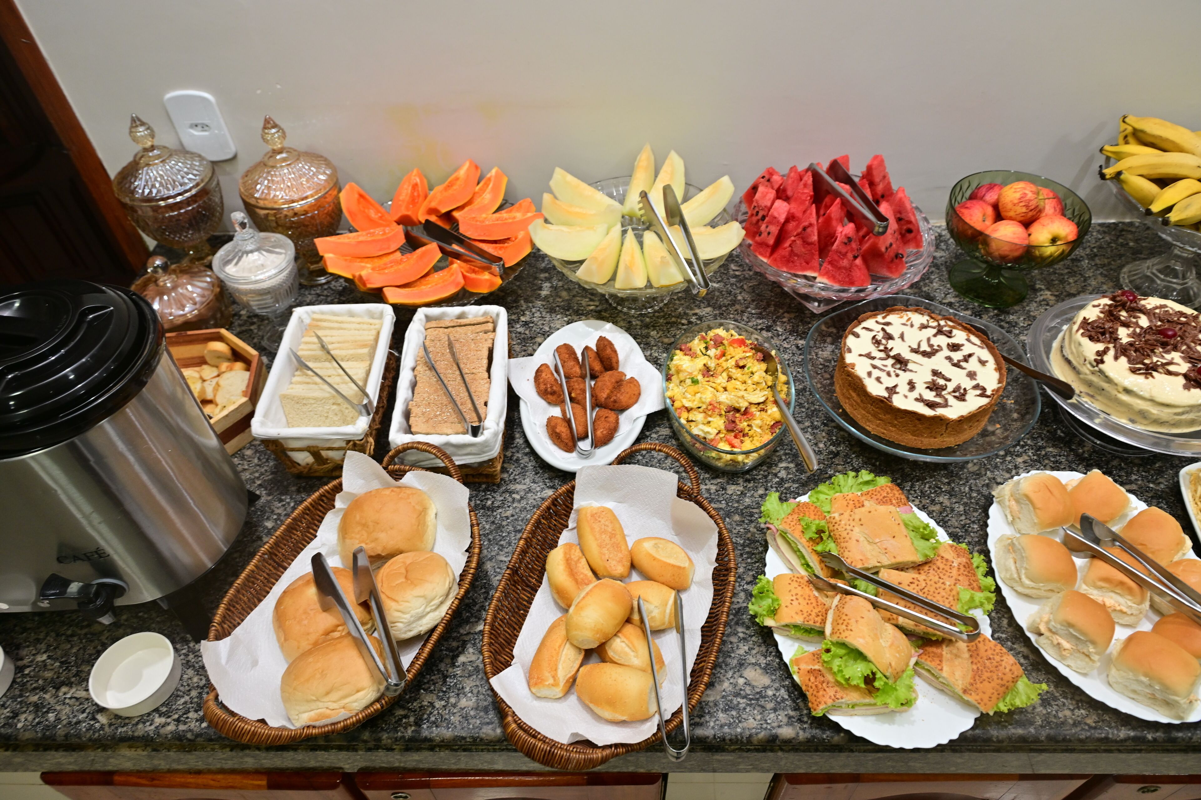 A buffet with various food items and utensils.