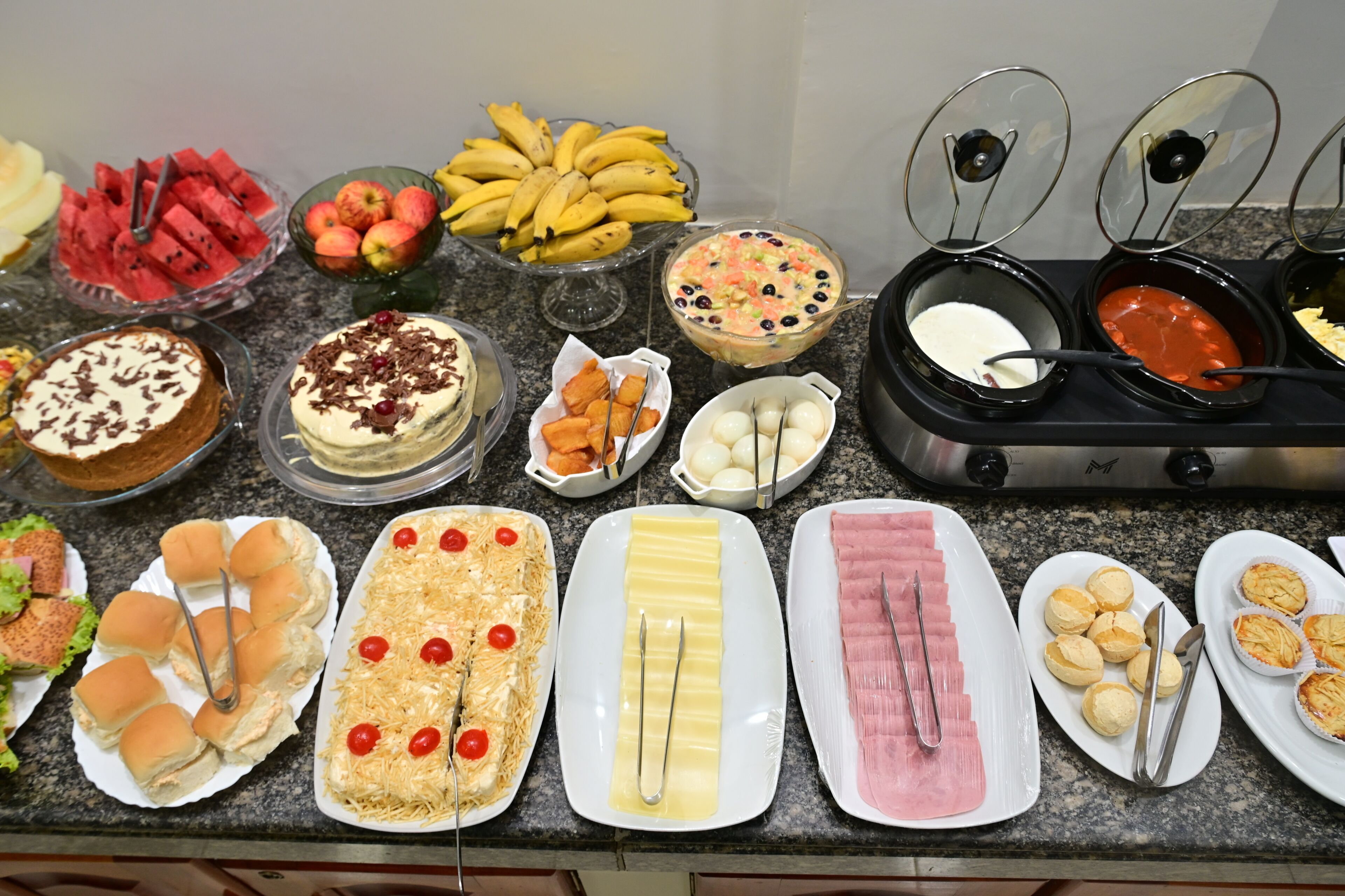 A buffet with various food items including fruits, desserts, and appetizers.