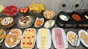 A buffet with various food items including fruits, desserts, and appetizers.