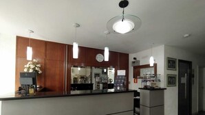 A reception area with a wooden counter, a clock, and a refrigerator. - Hotel Dublin (São Paulo)