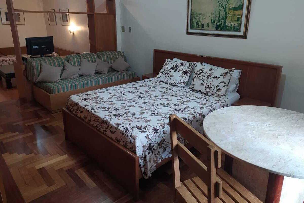 Une chambre à coucher avec un lit, un canapé, un bureau et une chaise.