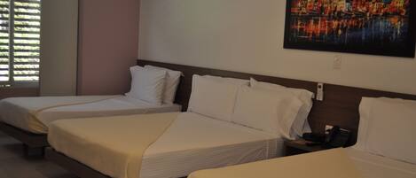 A hotel room with three beds, a painting on the wall, and a window with blinds.